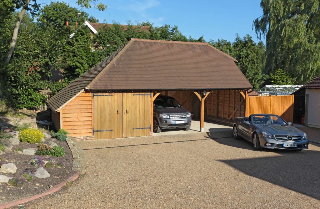 A 3 bay oak garage with luxury cars parked inside
